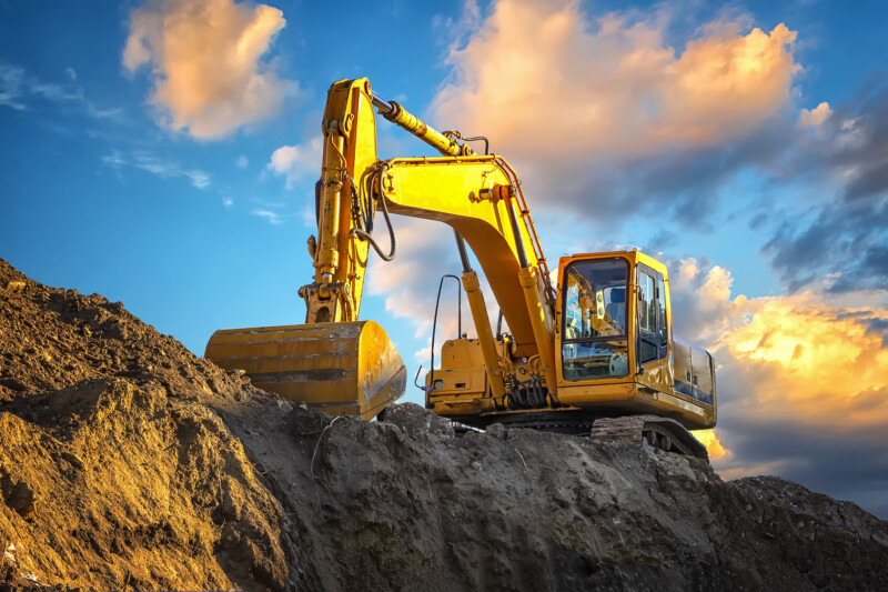 A stopping yellow excavator at an incredibly beautiful sunset